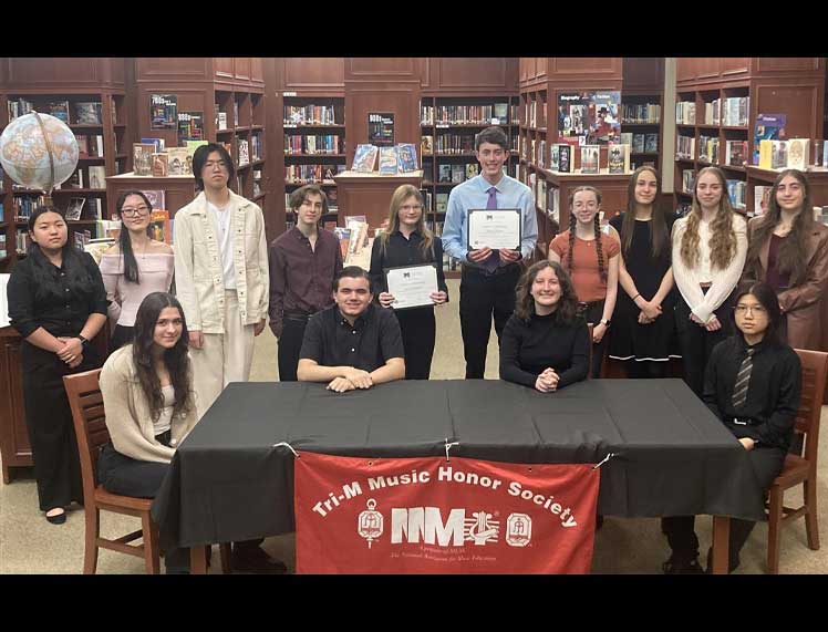 Ava Romonoyske and Sean Grossman flanked by members of the Earl L. Vandermeulen High School Tri-M Music Honor Society